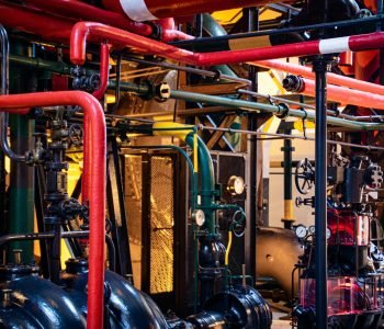 Complex network of industrial pipes and machinery inside a Lisbon plant.